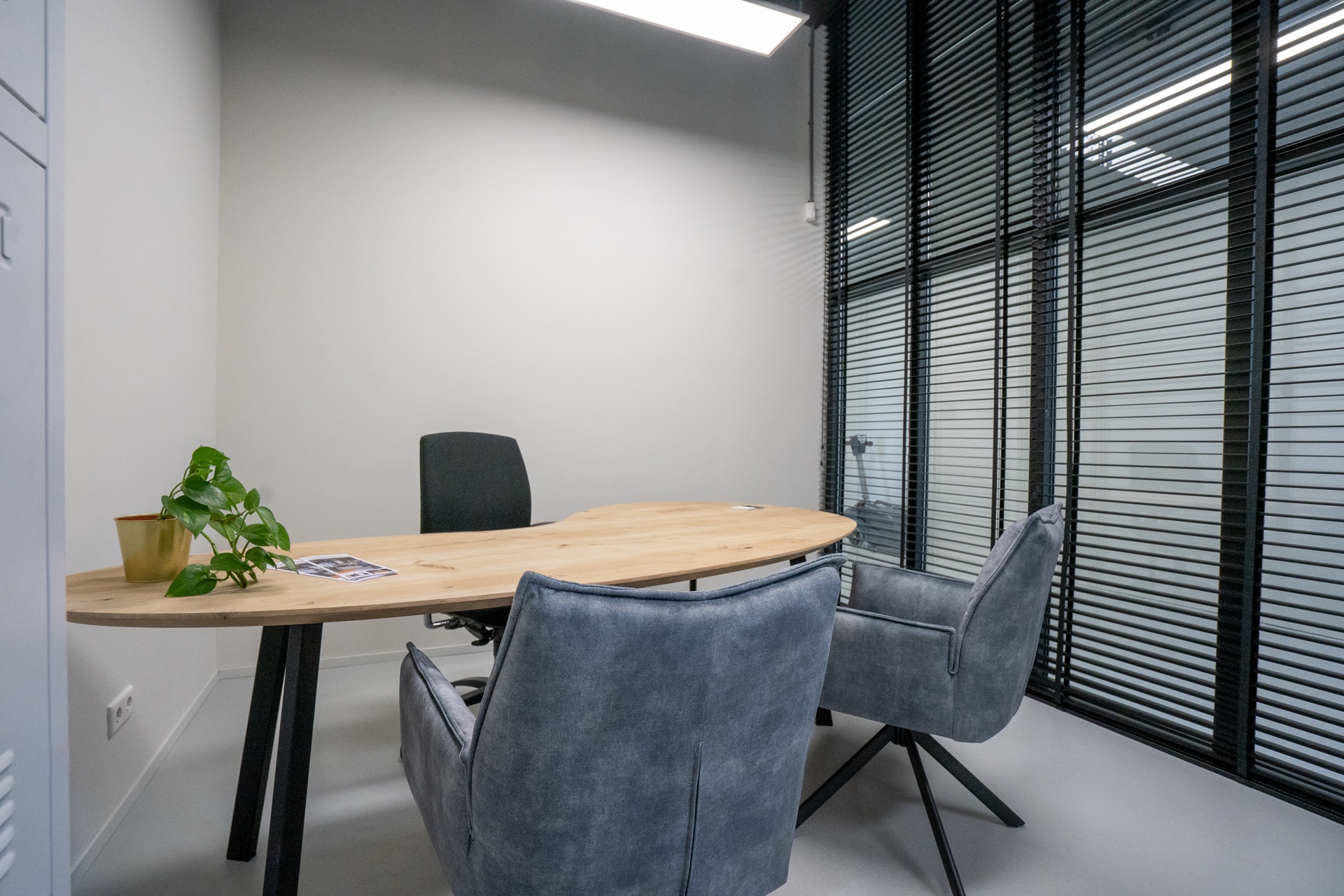 Flexkantoor S2 — ovale werktafel met grijze stoelen langs glazen wand