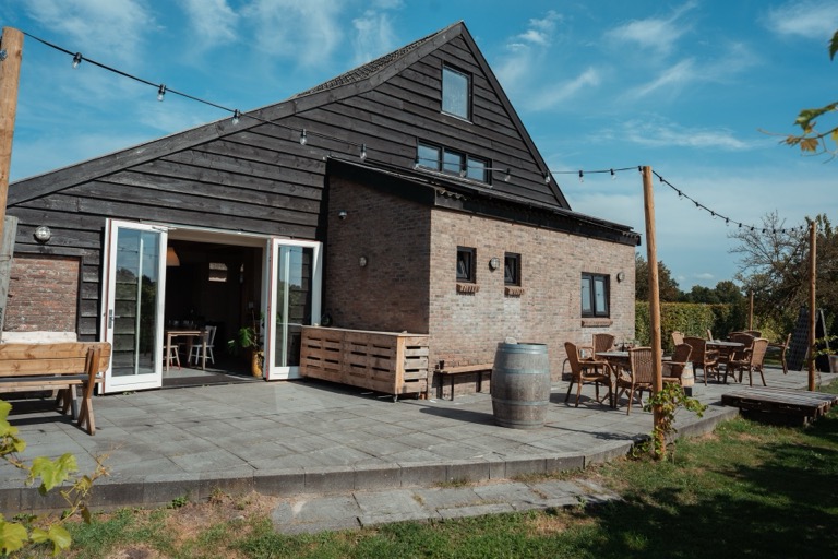 Vooraanzicht van het proefhuis met terras en lichtsnoeren