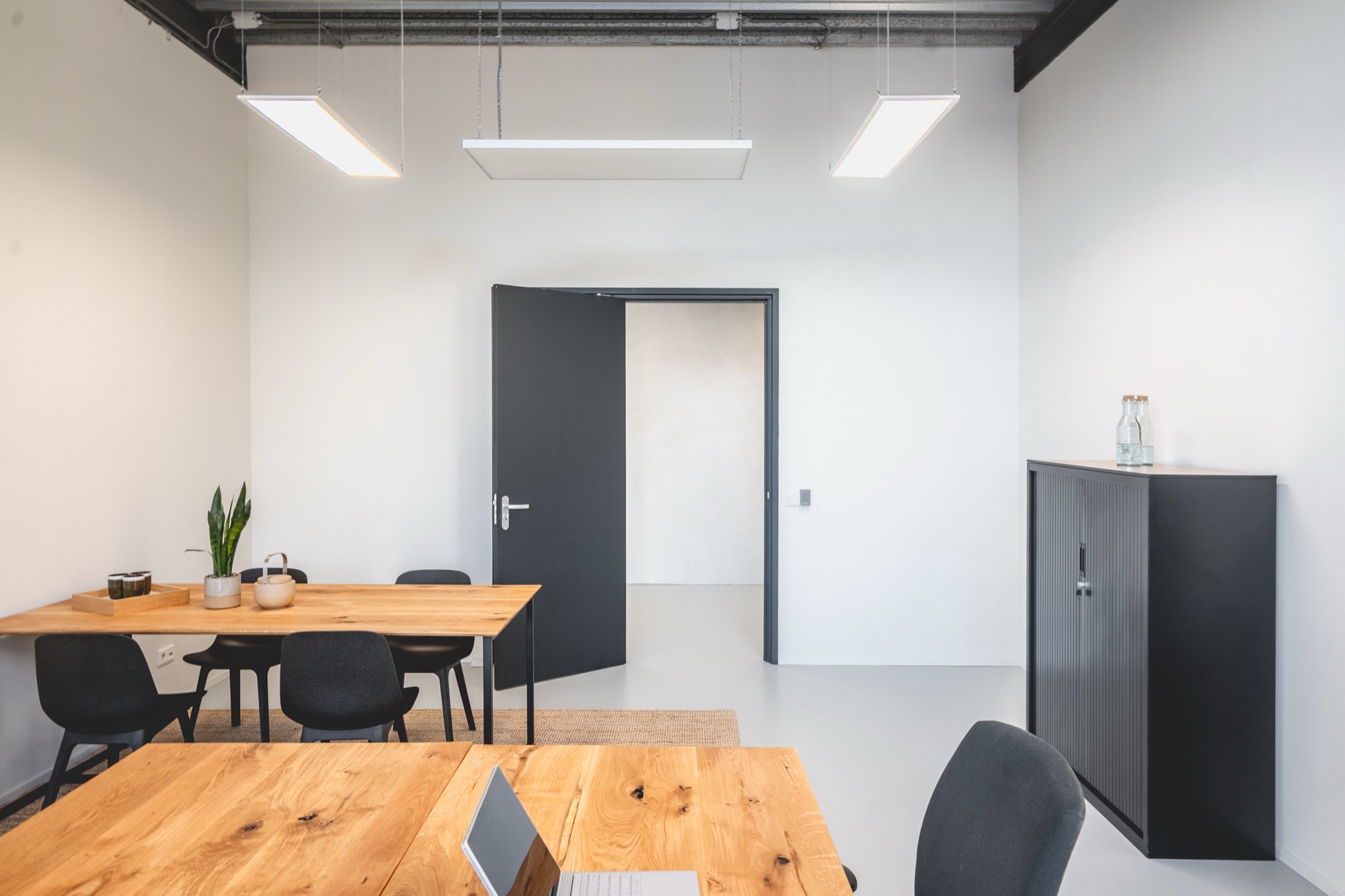 Vast kantoor met oak werktafels en industrieel stalen plafond in Loods 038